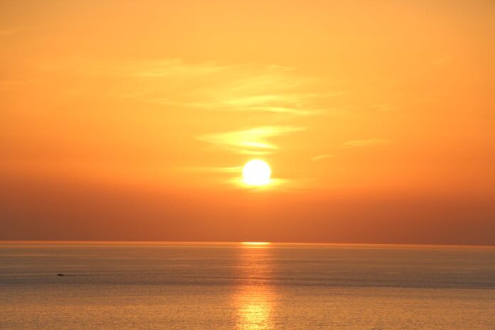 Beautiful orange sunset over the Ligurian Sea in Italy, highlighting serene ocean scenery.