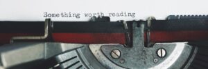 Close-up of a vintage typewriter with thePaulo Coelho: Frasi Sulla Vita e Sulla Crescita Personale phrase 'Something worth reading'.
